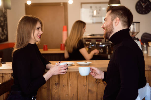 istock Beautiful Woman And Handsome Man Drinking Coffee While Spending Time In Coffee Shop. 1307466193