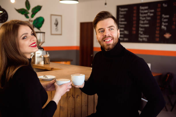 istock Beautiful Woman And Handsome Man Drinking Coffee While Spending Time In Coffee Shop. 1307466194
