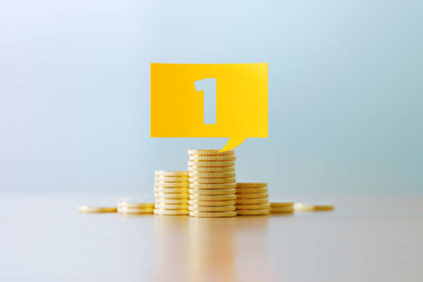 istock Budget Concept - Number 1 Written Yellow Speech Bubble Sitting Over Coin Stacks Before Defocused Background 1307467225