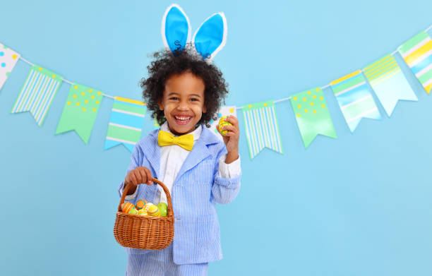 istock happy ethnic child boy with easter eggs and bunny ears on blue background 1307468070