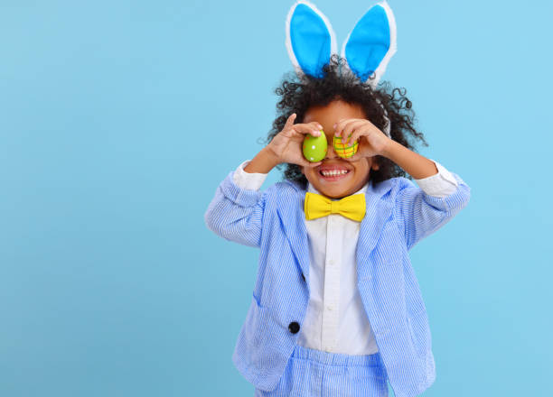 istock happy ethnic child boy with easter eggs and bunny ears on blue background 1307468611