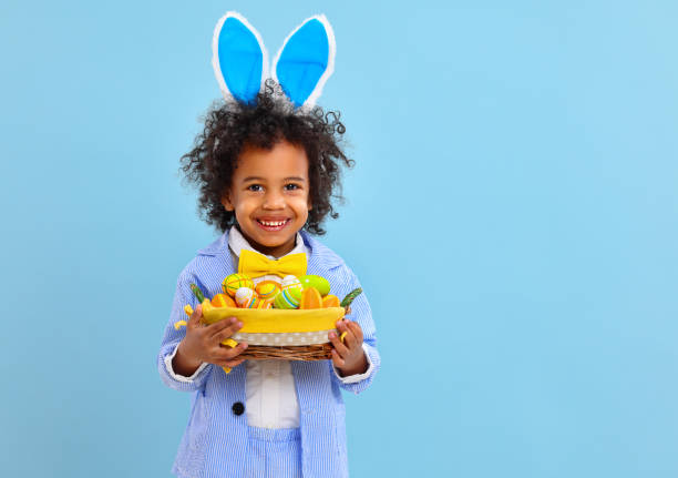 istock happy ethnic child boy with easter eggs and bunny ears on blue background 1307468652