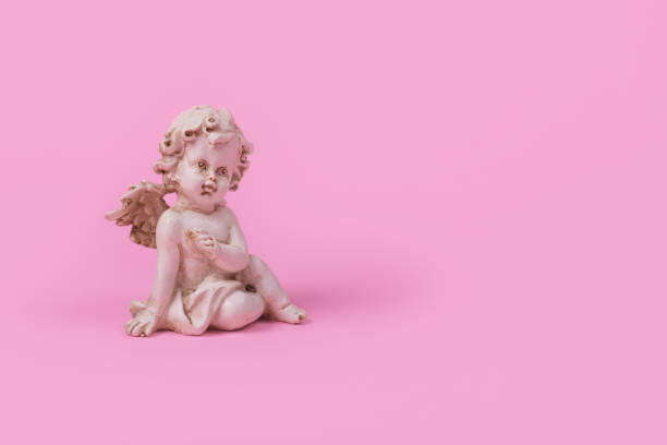 istock Minimal creative idea with a white angel on a pink background. 1307469757