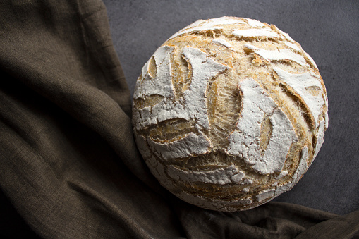 Artisan bread on gray background with copy space. Homemade sourdough bread recipes. Healthy eating concept.