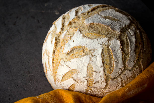 istock Beautifully scored bread on yellow linen towel 1307472483
