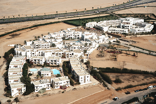 Aerial view from the plane on white houses of touristic resort in desert in Sinai Peninsula near Sharm El Sheikh, Egypt