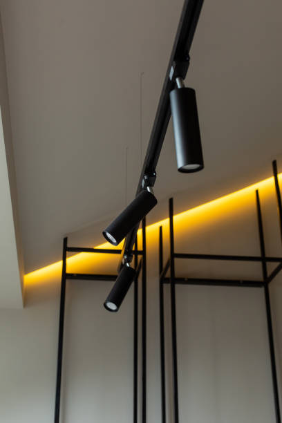 istock Modern lamp hanging from the ceiling with a white wall. 1307474400