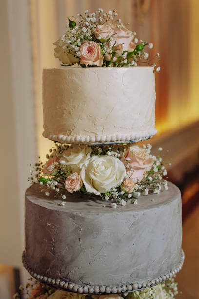 istock white floral wedding cake on restaurant interior background 1307474944