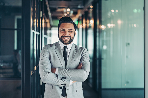 Portrait of a smiling Middle-Eastern ethnicity businessman standing in the corridor