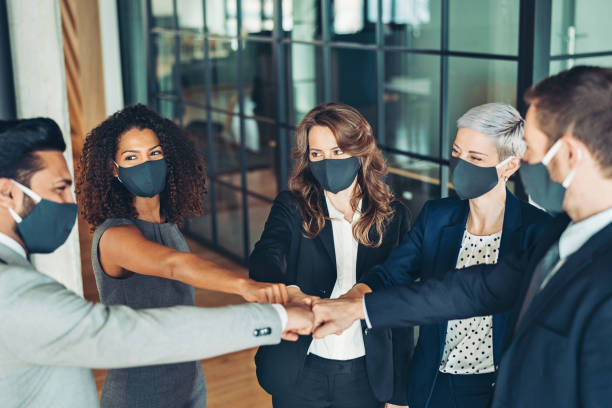 istock Business persons with protective face masks making group fist bump 1307477223