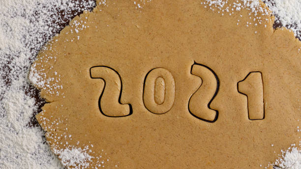 istock 2021 numbers cut from rolled raw cookie dough on flour black table 1307477966