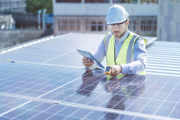 istock engineer man inspects construction of solar cell panel or photovoltaic cell by electronic device. Industrial Renewable energy of green power. factory worker working on tower roof. 1307480726
