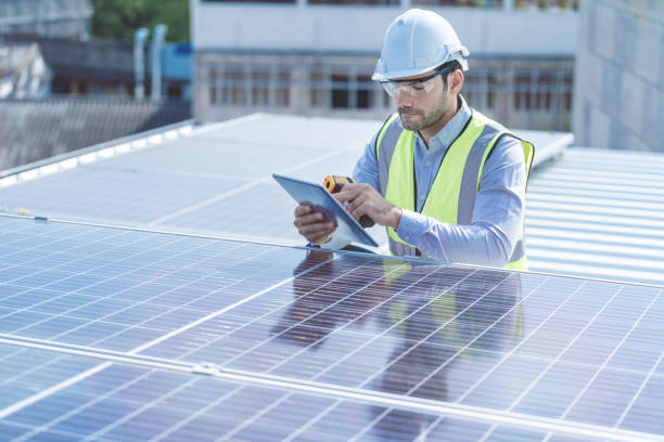 istock engineer man inspects construction of solar cell panel or photovoltaic cell by electronic device. Industrial Renewable energy of green power. factory worker working on tower roof. 1307481122