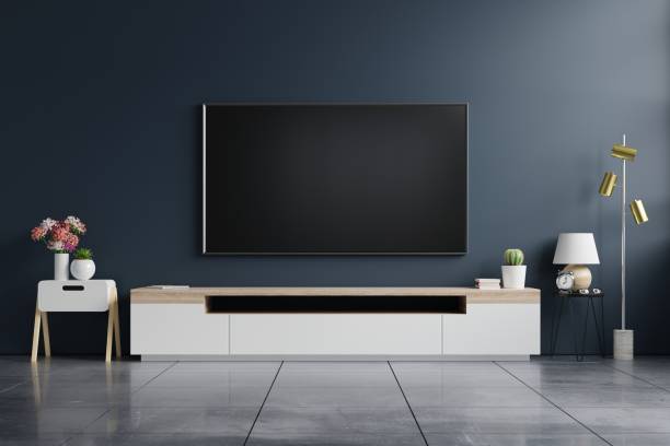 istock Mockup tv on cabinet in modern empty room with behind the dark blue wall. 1307484564