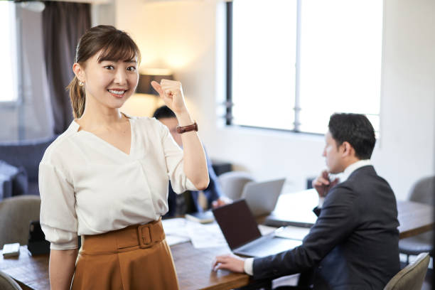 a woman doing a guts pose at an english conversation meeting between asians and latins - chinese ethnicity latin american and hispanic ethnicity multi ethnic group business person imagens e fotografias de stock