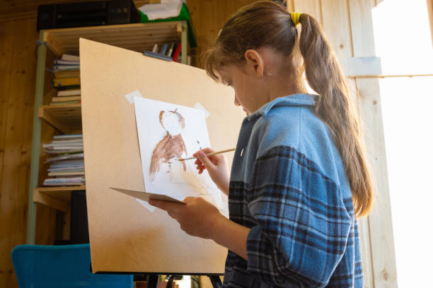 istock A ten-year-old girl draws with paints on an easel 1307487905