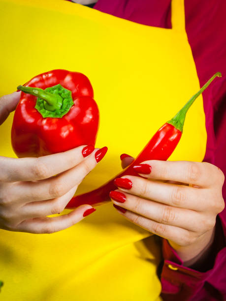 istock Woman holding bell pepper and chilli 1307490898