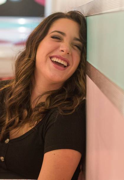 istock Girl leans against wall while she is laughing 1307491121