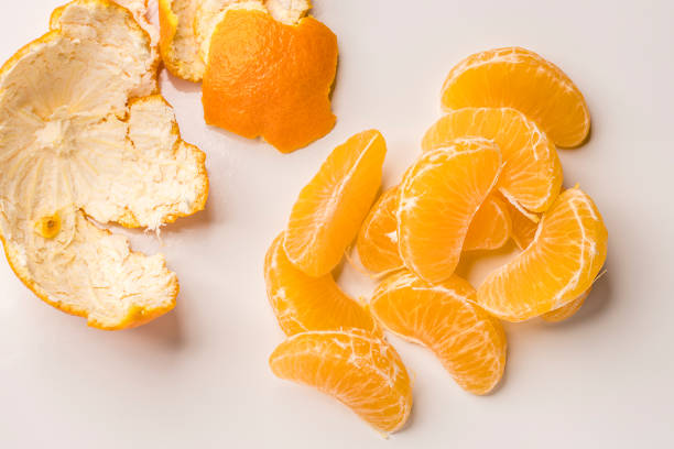 An overview of orange slices and the peels on a white background.