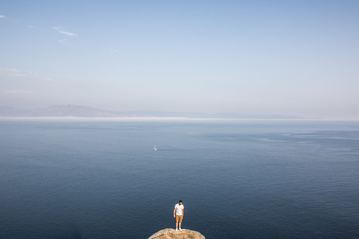 Man standing on a rock with the Atlantic ocean in the background