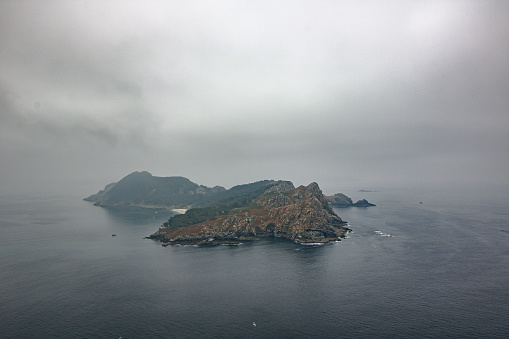 Island surrounded by clouds in a foggy day. The picture is one natural park in the Cies Island, Galicia