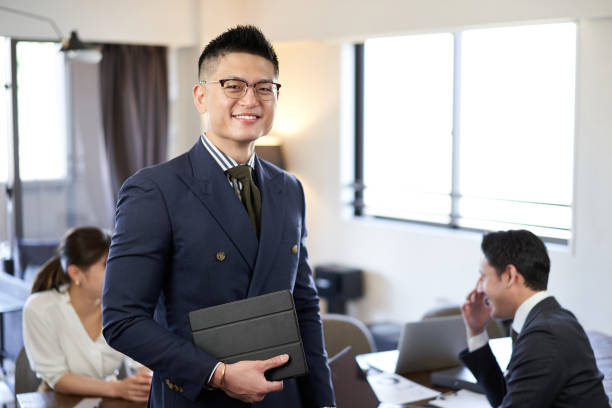 a smiling man at an english conversation meeting between asians and latins - chinese ethnicity latin american and hispanic ethnicity multi ethnic group business person imagens e fotografias de stock