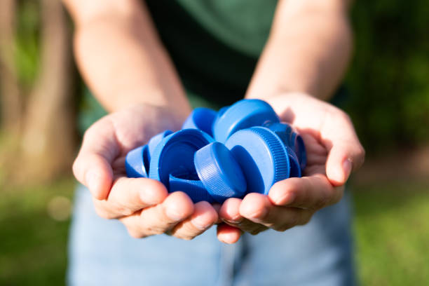 Recycling, a person holding plastic bottle caps with two hands Recycling, a person holding plastic bottle caps with two hands bottle cap stock pictures, royalty-free photos & images