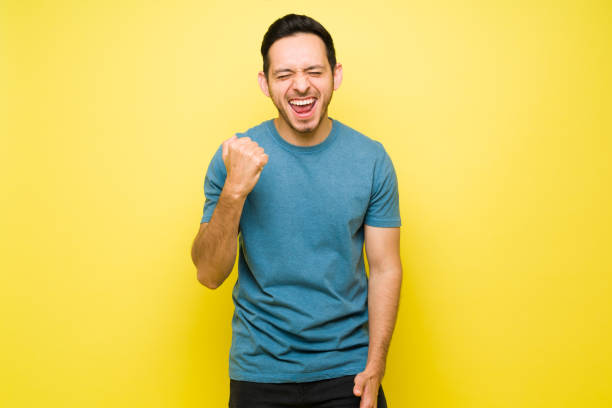 istock Successful hispanic man cheering for his triumph 1307503624