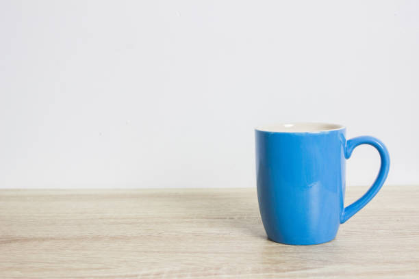 istock A blue coffee cup on a wooden table on a white wall. 1307504547