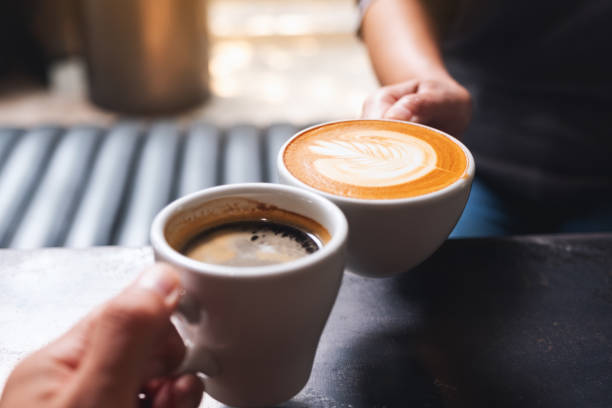 istock a man and a woman clinking white coffee mugs in cafe 1307506865