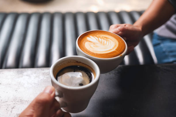 istock a man and a woman clinking white coffee mugs in cafe 1307506880