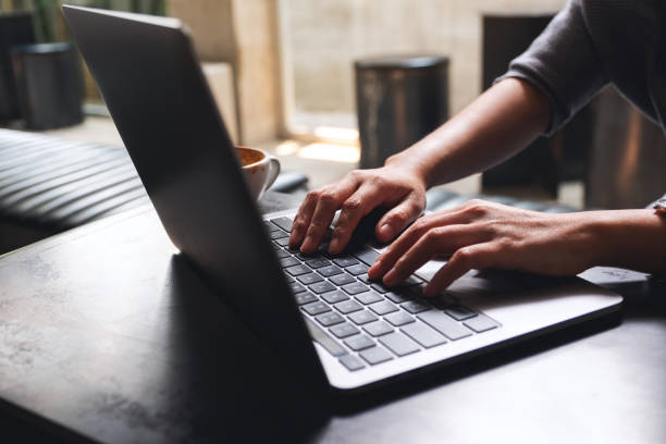 eine frau, die auf der laptop-computertastatur auf dem holztisch arbeitet und tippt - touchpad laptop computer software human finger stock-fotos und bilder