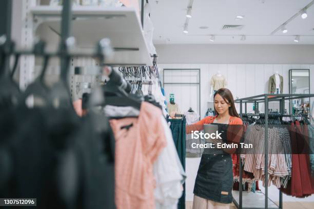 Asian Chinese Female Boutique Shop Clothing Store Owner Checking Stock With Digital Tablet Stock Photo - Download Image Now