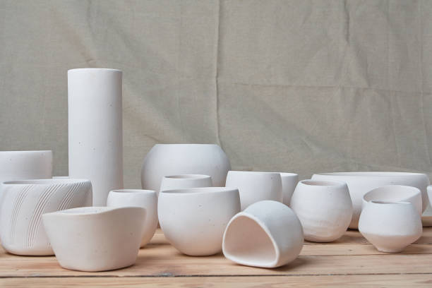 istock Unglazed white clay pots on wood table 1307515611