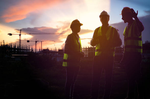istock Teamwork, worker in uniform and wearing safety helmet while working on commercial dock site with container box from cargo freight ship for import export. 1307516464