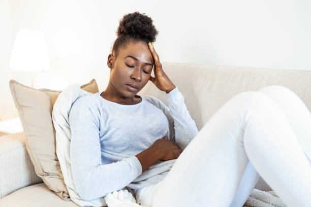 istock Depressed black young woman sit on sofa down upset having personal relationships problems, stressed millennial african American girl touch head feel despair mourning or grieving of loss 1307517349