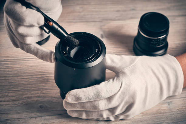 istock Man cleans photo lens with brush 1307517401