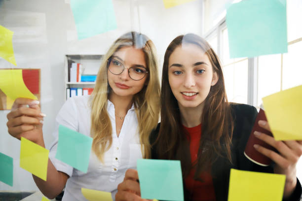 istock Two businesswomen looking at sticky notes 1307517925