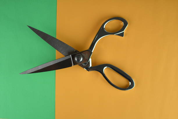 istock silver scissor on green and orange background 1307521509