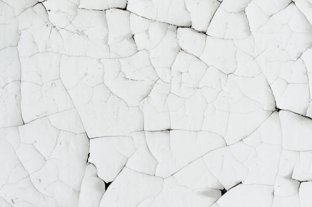 istock Surface texture with cracked peeling paint. Old white paint on wall. 1307522797