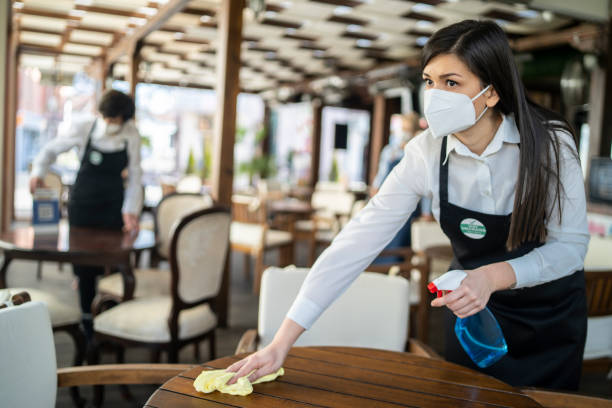 istock Restaurant staff that is vaccinated against COVID-19 is disinfecting a table for customers 1307523774