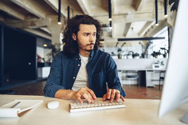 istock Young businessman, successful freelancer working online on computer, sitting in modern office 1307524741