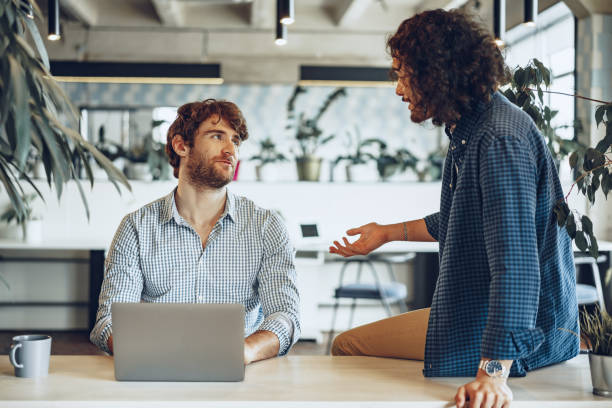 istock Two young businessmen discussing some ideas in modern office 1307525484