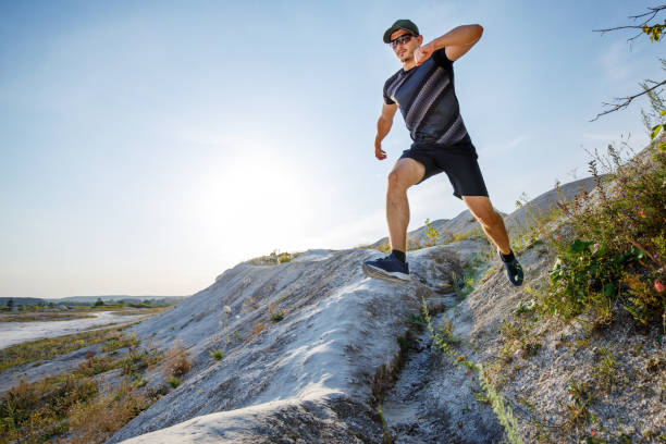 istock young fit man jumping on his trail running on hill 1307526785
