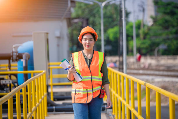 Worker wearing safety uniform under checking the waste water treatment pond industry ,she used radio communication to connect with another worker in large to control water support industry. trabajadora con uniforme de seguridad bajo la comprobación de la industria de estanques de tratamiento de aguas residuales, utilizó la comunicación por radio para conectarse con otro trabajador en general para controlar la industria de apoyo al agua.