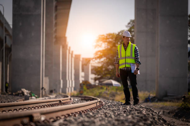 engineer railway under inspection and checking construction process railway and checking work on railroad station .engineer wearing safety uniform and safety helmet in work. - switch yard imagens e fotografias de stock