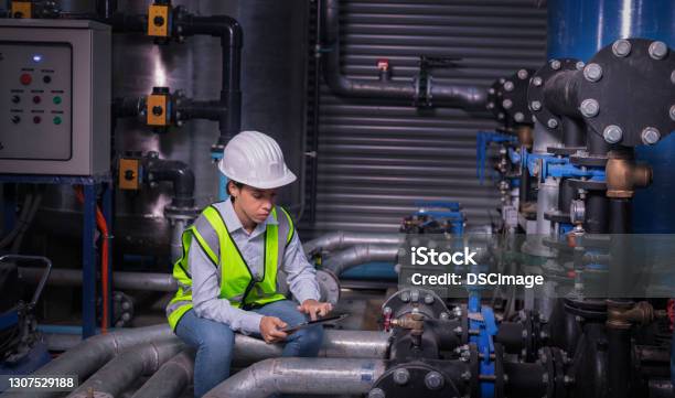 Industry Engineer Worker Wearing Safety Uniform Under Checking The Industry Cooling Tower Air Conditioner Is Water Cooling Tower Air Chiller Hvac Of Large Industrial Building To Control Air System Stock Photo - Download Image Now