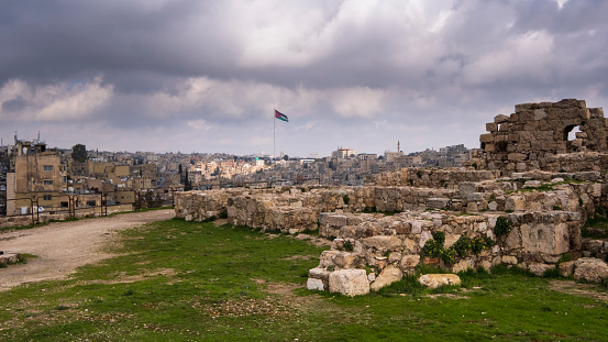 Las ruinas de la ciudadela sobre la ciudad de Ammán en Jordania con bandera de país photo