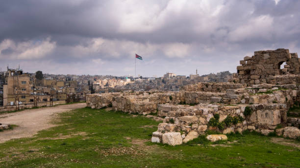 ruiny cytadeli nad miastem amman w jordanii z flagą kraju - amman zdjęcia i obrazy z banku zdjęć