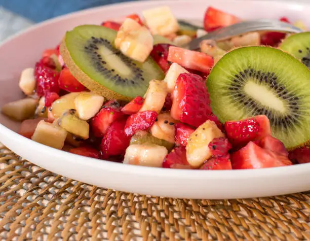 Homemade fresh prepared fruit salad with strawberries, kiwis and bananas served on a plate